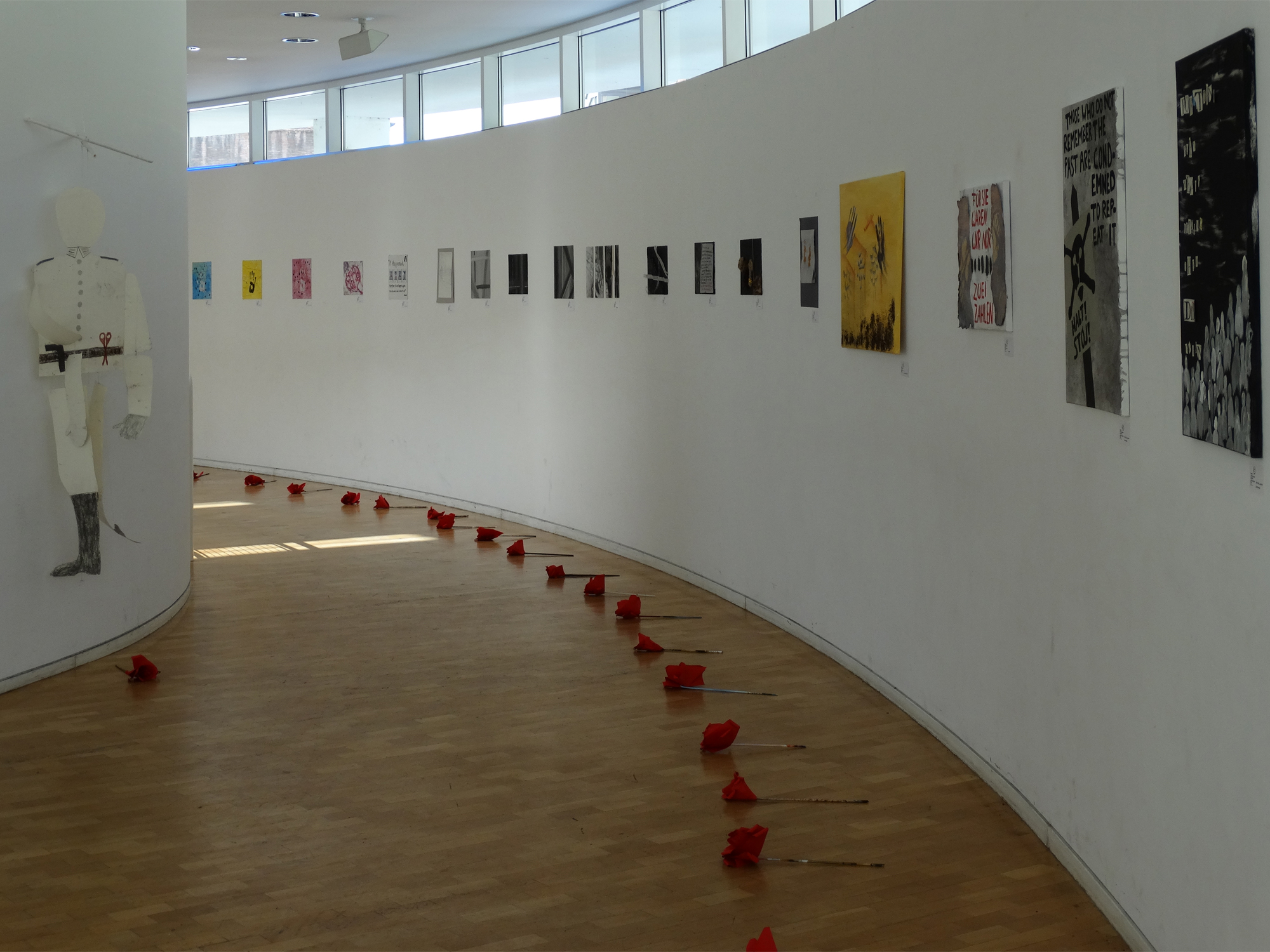 Die Ausstellung im Saal-Foyer des Stadthauses Die Ausstellung im Saal-Foyer des Stadthauses. Vor den Bildern liegen rote Rosen aus Krepppapier