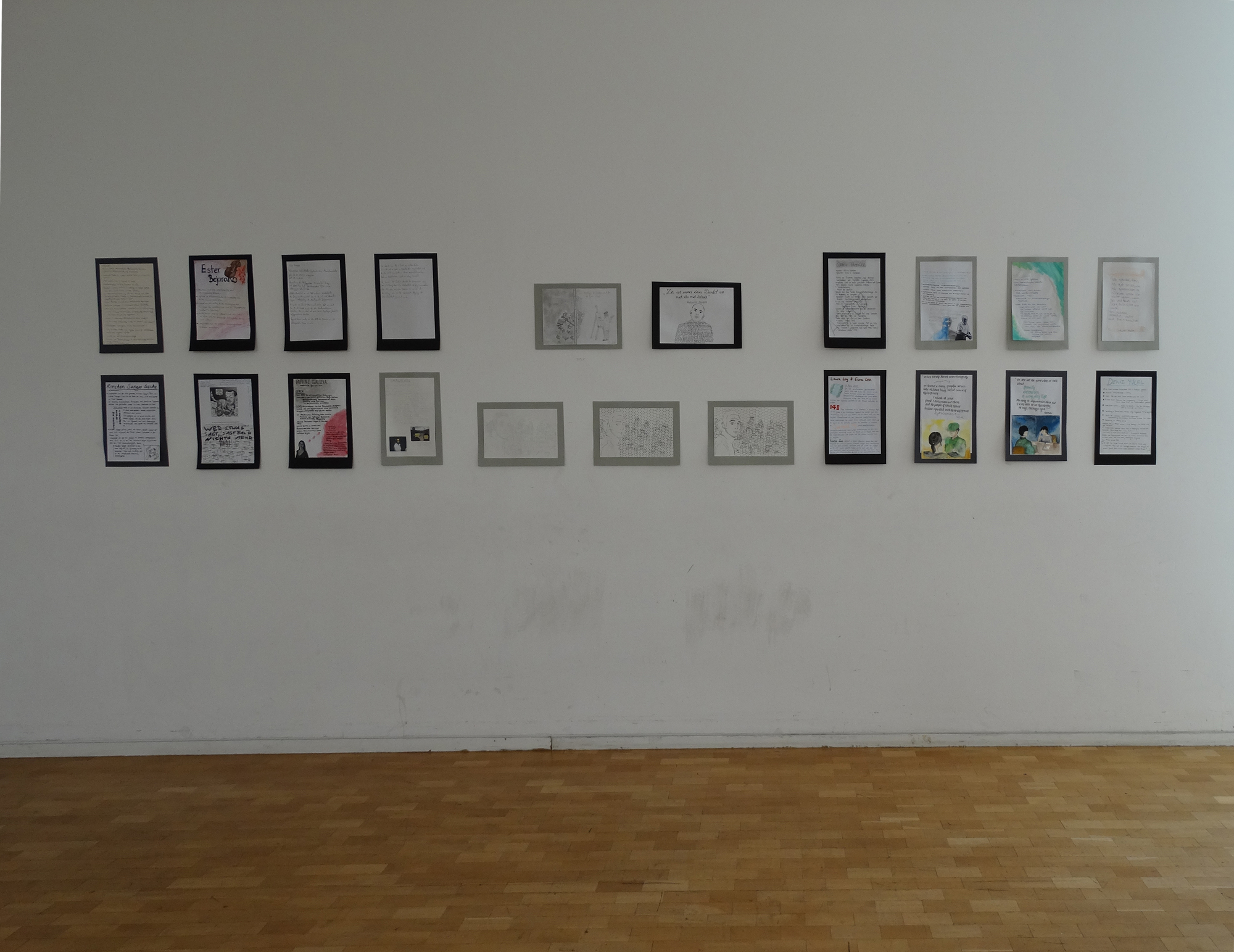 Arbeiten von Schülerinnen und Schülern. Bilder von Schülerinnen und Schülern hängen in der Ausstellung.
