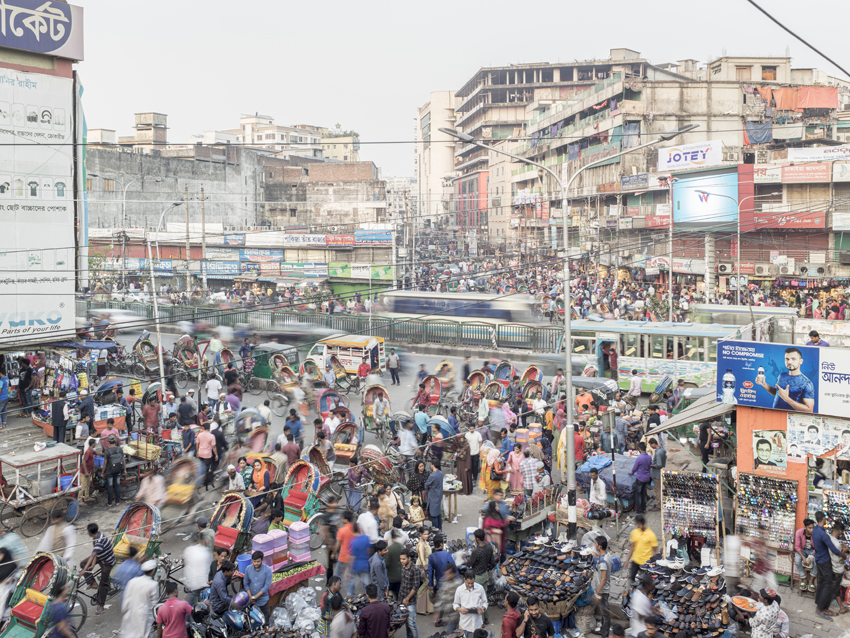 Straßenszene in Dhaka, der Hauptstadt von Bangladesch. Gebäude und Gewimmel auf der Straße sind zu sehen. 