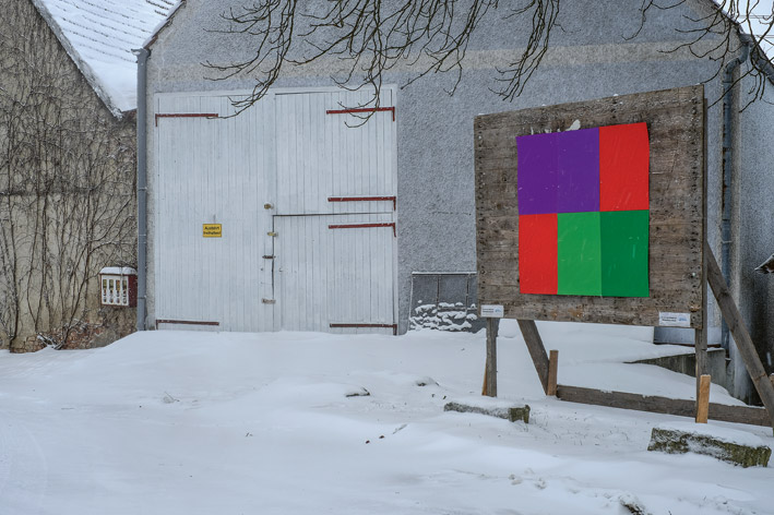 Birte Horns Werk an einer Plakatwand vor einem Haus